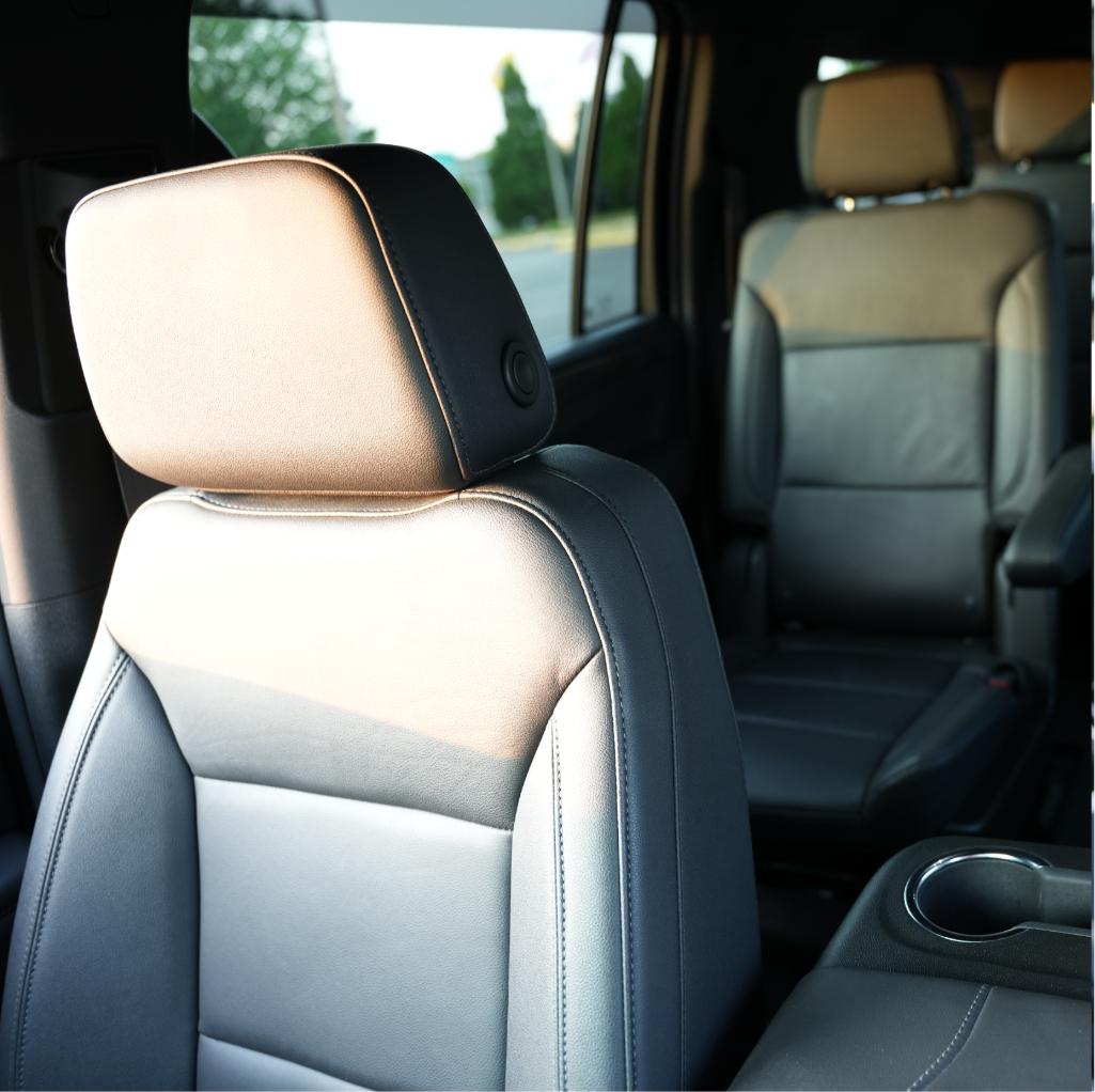 Close-up of luxury SUV leather captain’s seats with armrests and cupholder for New Jersey chauffeur and airport transfer service.