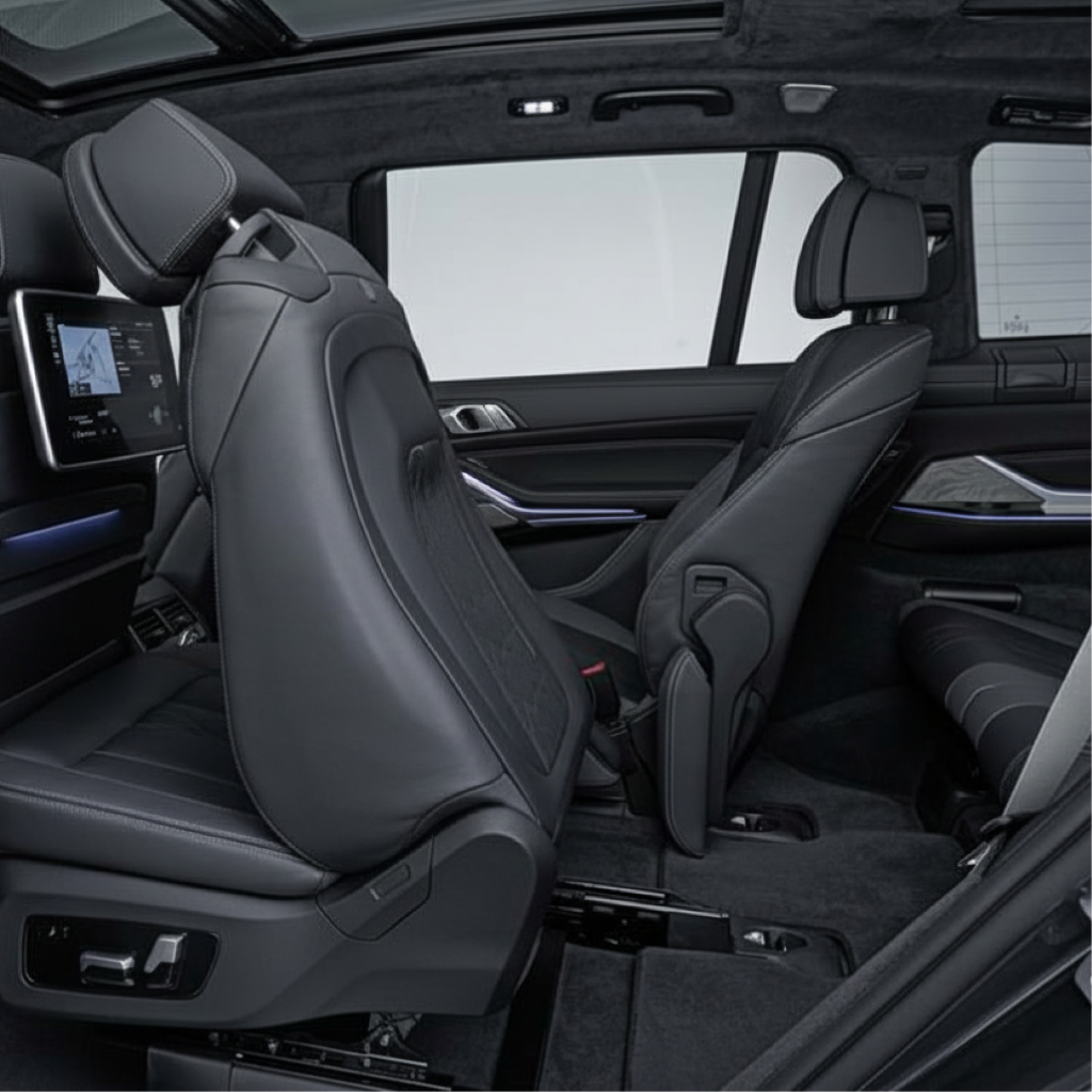 BMW X7 rear cabin in New Jersey showing leather seats, seatback display, and fold-forward second row for third-row entry—chauffeur airport transfer SUV.