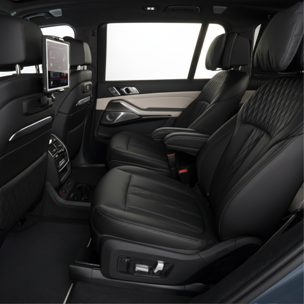 BMW X7 interior in New Jersey showing two leather captain’s chairs with armrests, seatback entertainment screen, and spacious rear cabin for chauffeur service.