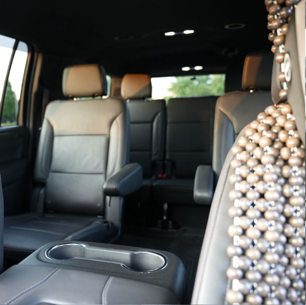 Interior of a luxury SUV showing leather captain’s chairs, third-row seating and center cupholder—ideal for New Jersey airport transfers and hourly service.