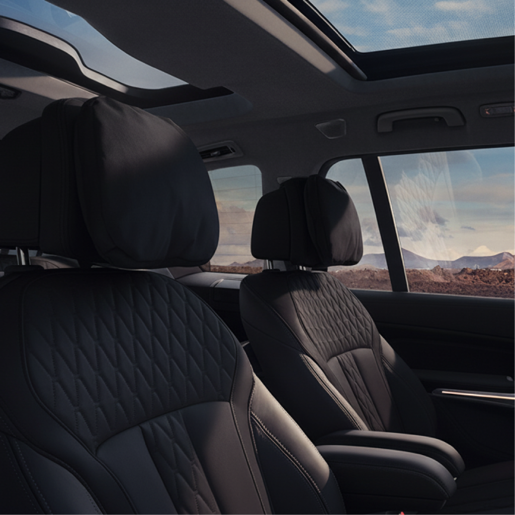Luxury SUV interior showing quilted leather captain’s chairs and panoramic sunroof for New Jersey chauffeur service.