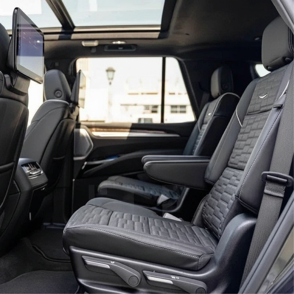 Interior of an NJ chauffeur-driven SUV showing leather captain’s chairs with armrests and rear screens, suitable for airport transfer and private car service.